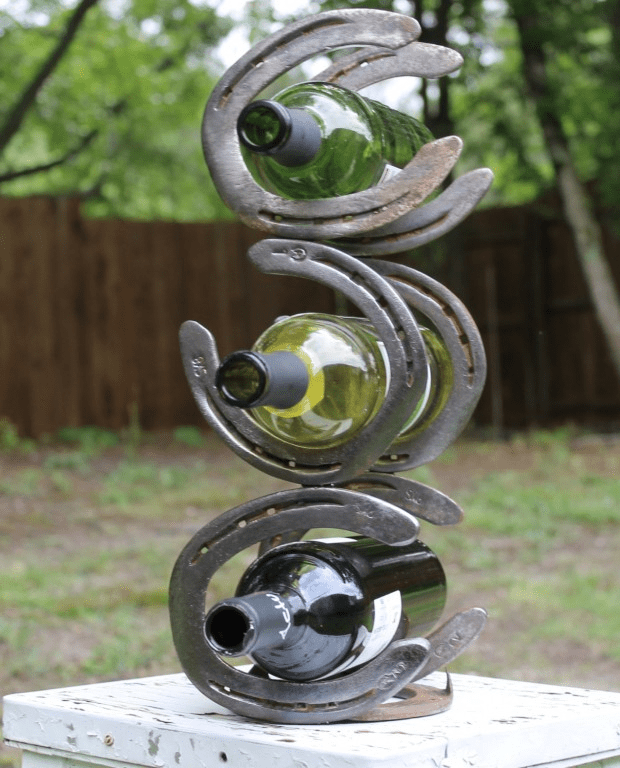 A picture of three horseshoes welded on top of each other with bottles inside them