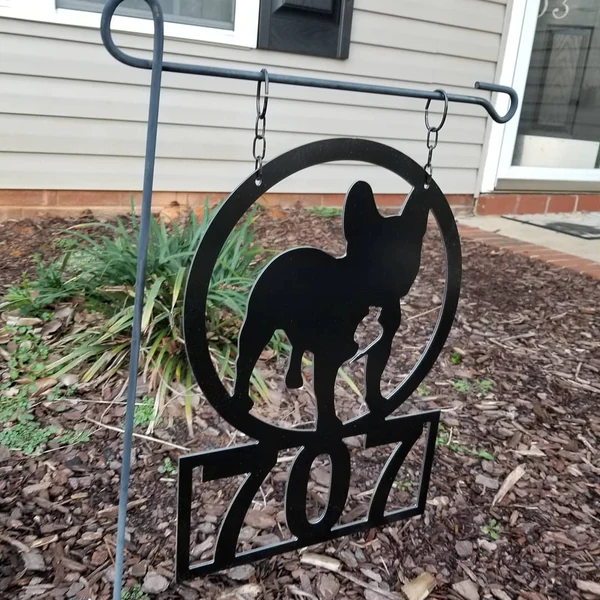 Image of a black hanging sign of a dog with the numbers 707 underneath