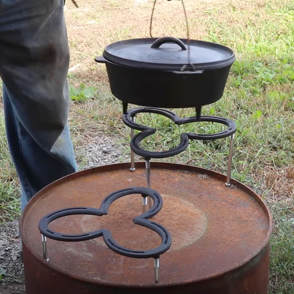 Image of two horseshoe holders with a pot being put on top of the one of the holder