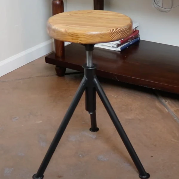 An image of a stool with a wooden seat and metal legs