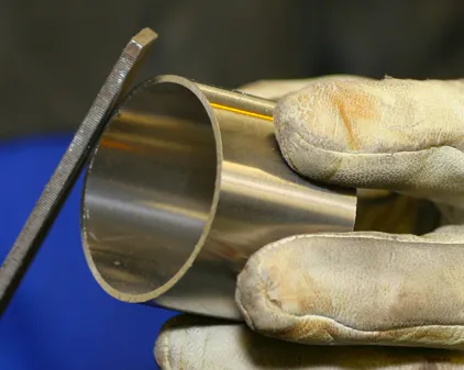 Image if a file being used to clean a stainless pipe for TIG welding