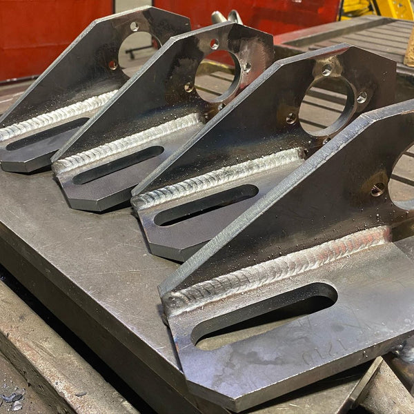 Image of four separate pieces of metals that have been welded on