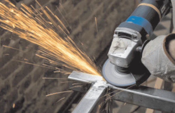 Image of a welder grinding nickel alloy to remove surface oxides