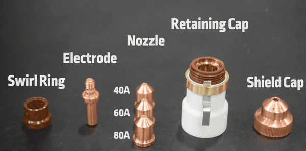 Image showing the components of a plasma cutting torch (from left to right: swirl ring, electrode, nozzle, retaining cap, shield cap)