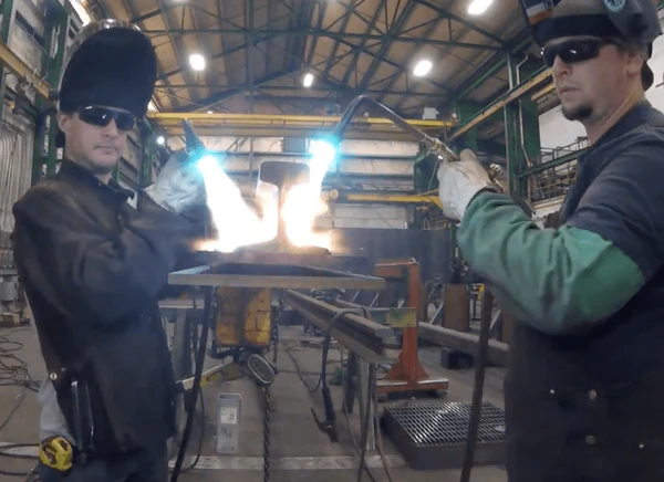 Image of two welders pre-heating a piece of high carbon steel